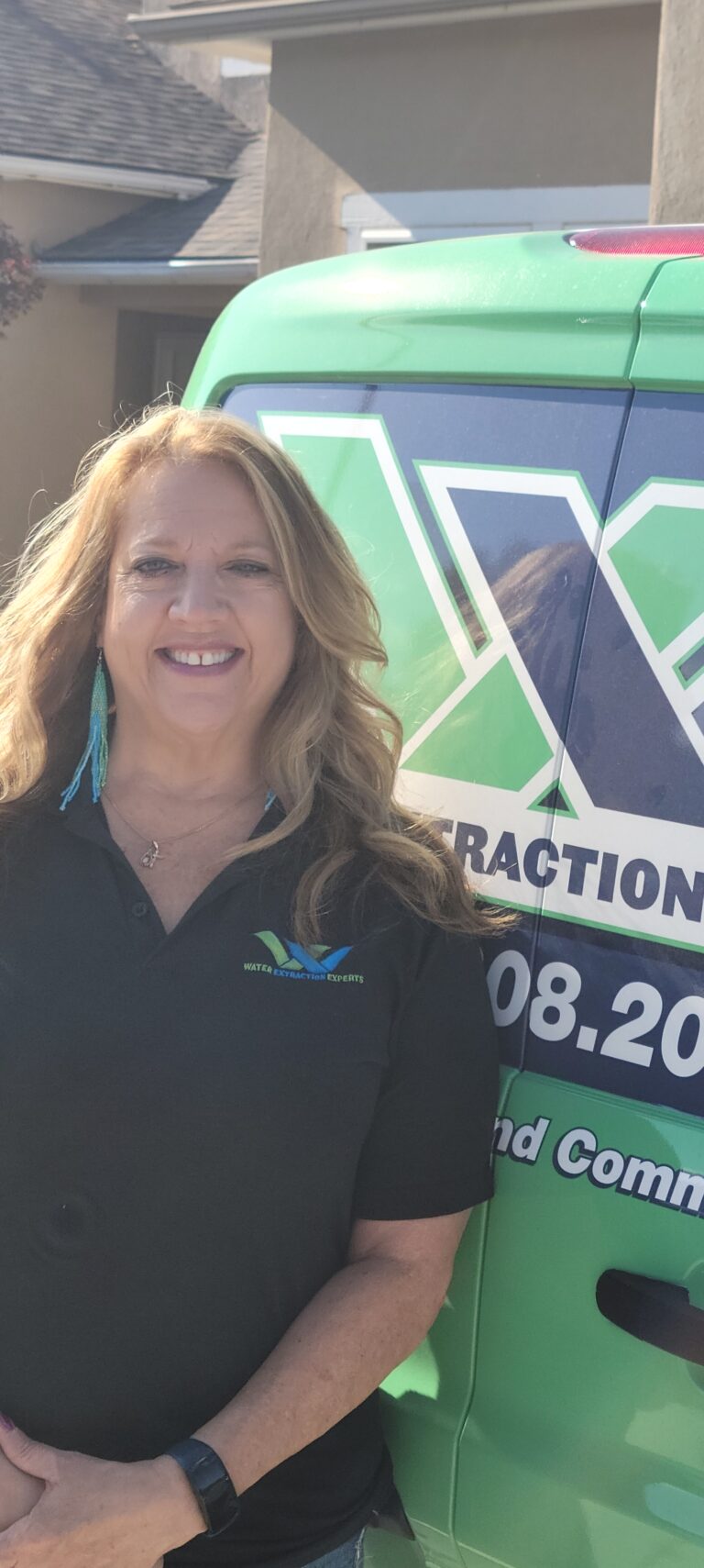 Carla an employee of Water Extraction Experts posing by the company van.